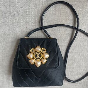 CHANEL Black Quilted Crossbody Bag with Pearl Flower Medallion